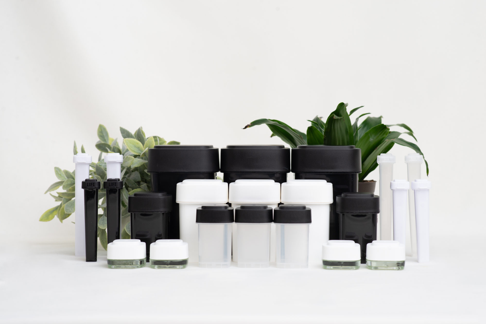 Collection of black & white non-branded Calyx Containers with plants in background
